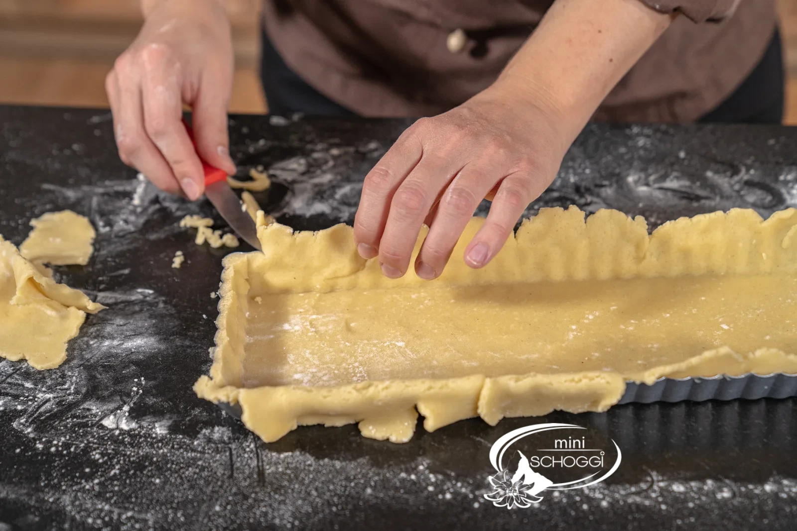 L'impasto in eccesso viene tagliato con un piccolo coltello