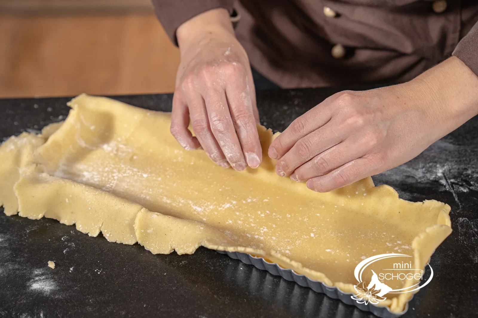La pasta frolla viene premuta con le dita nelle scanalature dello stampo