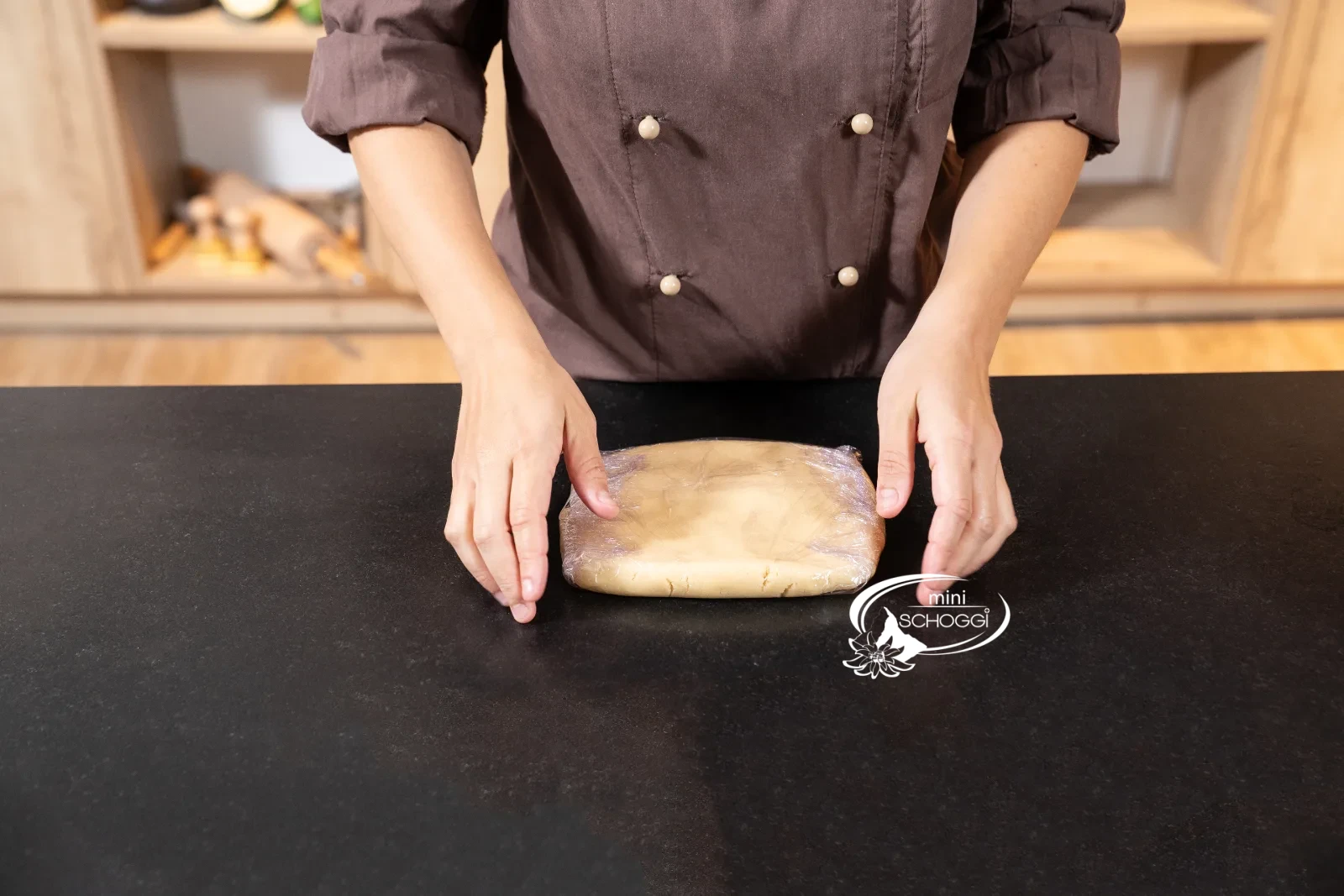 La lastra di pasta frolla appiattita è appoggiata sul piano di lavoro