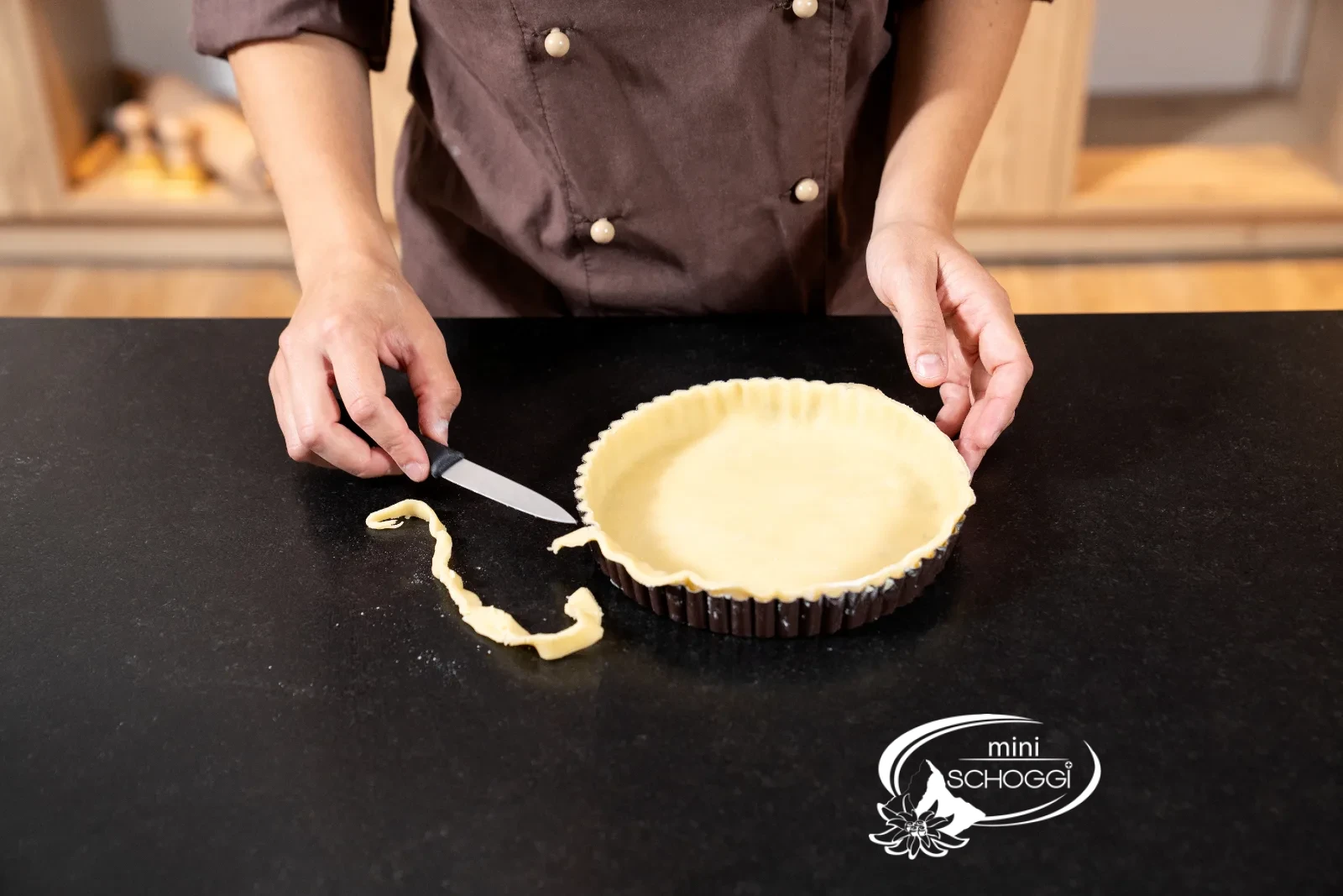 L'impasto in eccesso viene tagliato con un coltello lungo il bordo della Teglia per crostata
