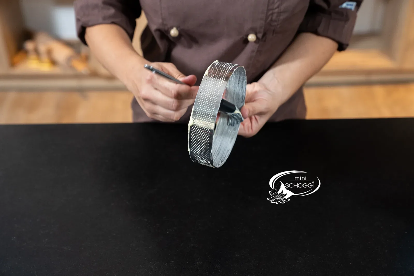 Perforierter Tortenring wird mit dem Pinsel mit Butter eingefettet