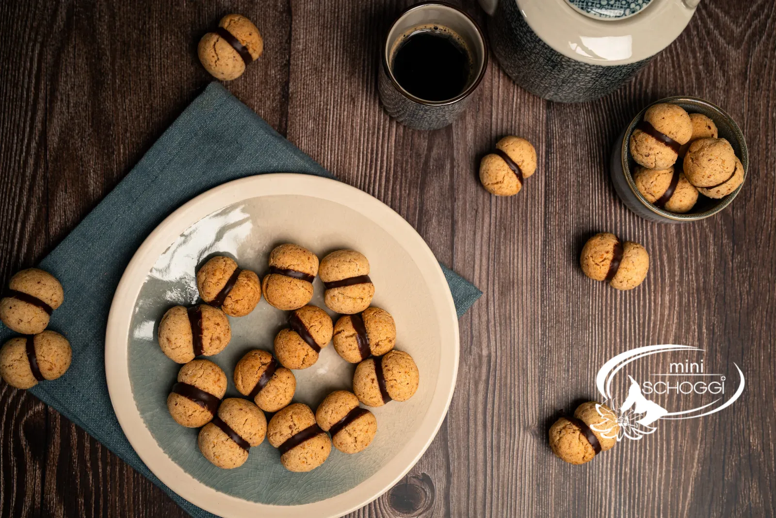 Baci di Dama sur une assiette et une table en bois avec du thé, vue de dessus