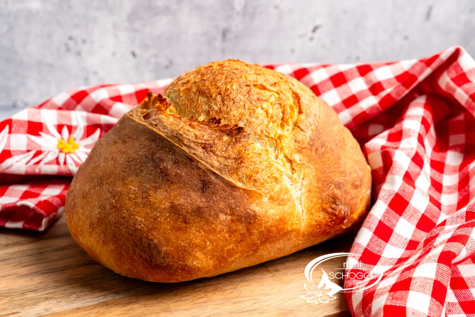 Freshly baked loaves and wheat ears on floured wood