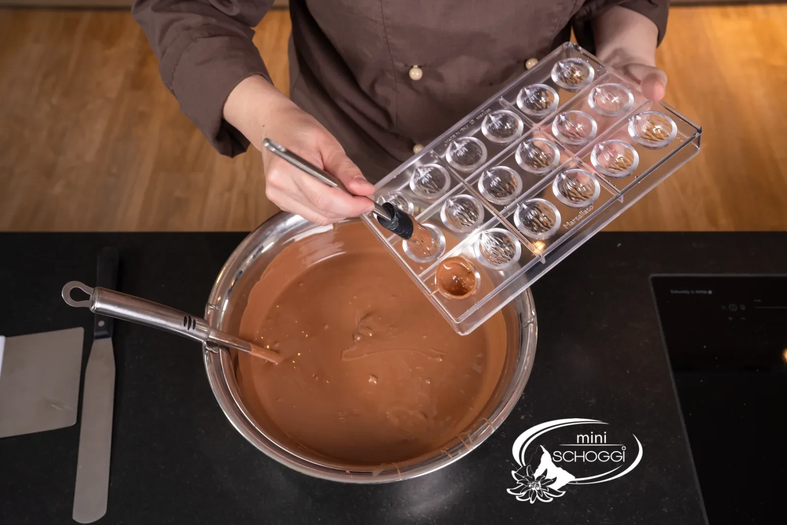 Lo stampo per praline viene spennellato con copertura al latte temperata