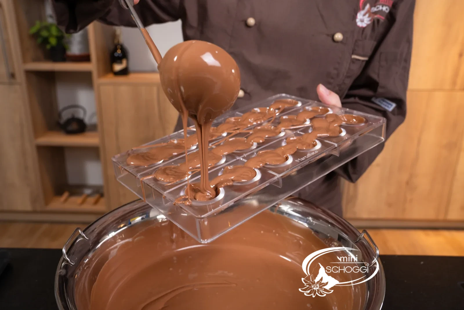 La copertura di cioccolato temperata viene versata nello stampo col mestolo