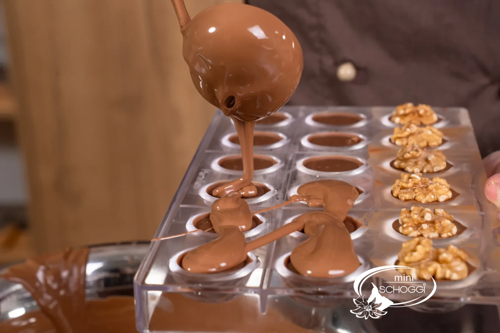 La copertura al latte temperata viene messa sulle praline per chiuderle