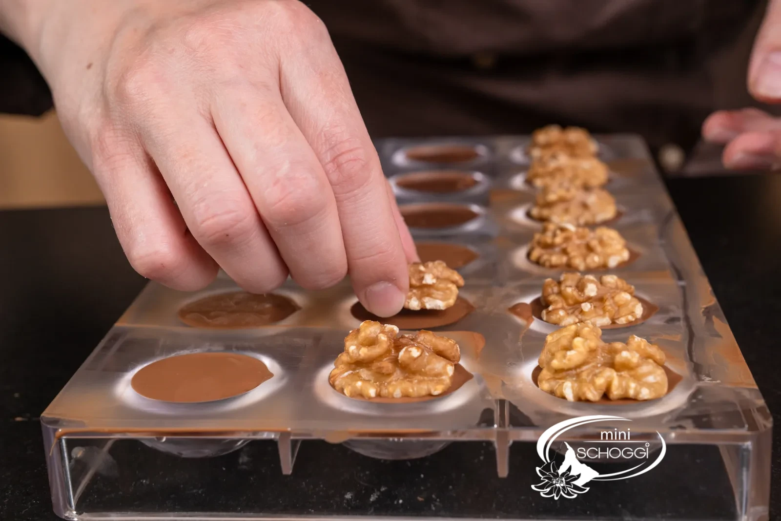 Le prossime sei praline vengono chiuse con la copertura di cioccolato