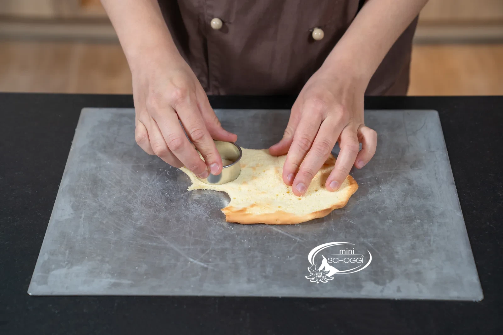 Runde Böden werden mit dem Patisserie-Ausstecher aus dem Biskuit ausgestochen