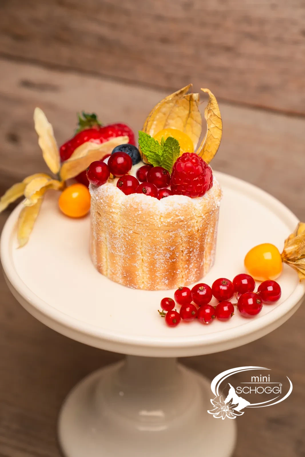 Beeren-Charlotten mit frischen Beeren und Physalis auf einer Tortenplatte