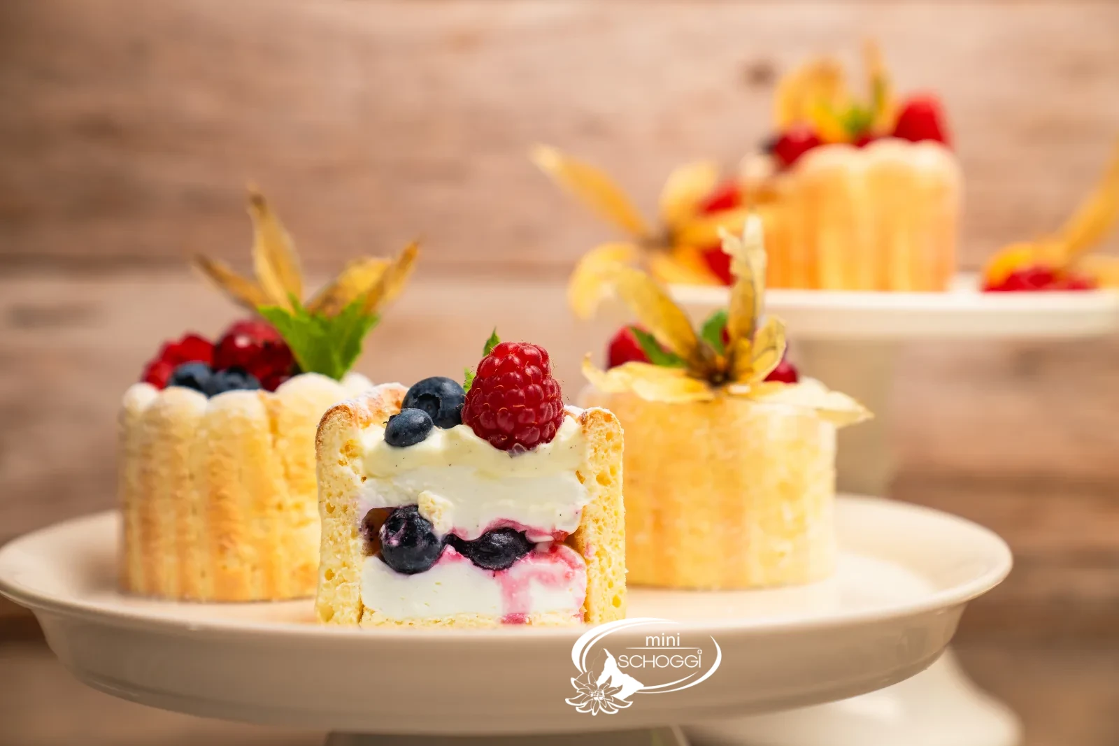 Angeschnittene Beeren-Charlotte mit Quarkcreme, Beeren und Löffelbiskuit-Rand