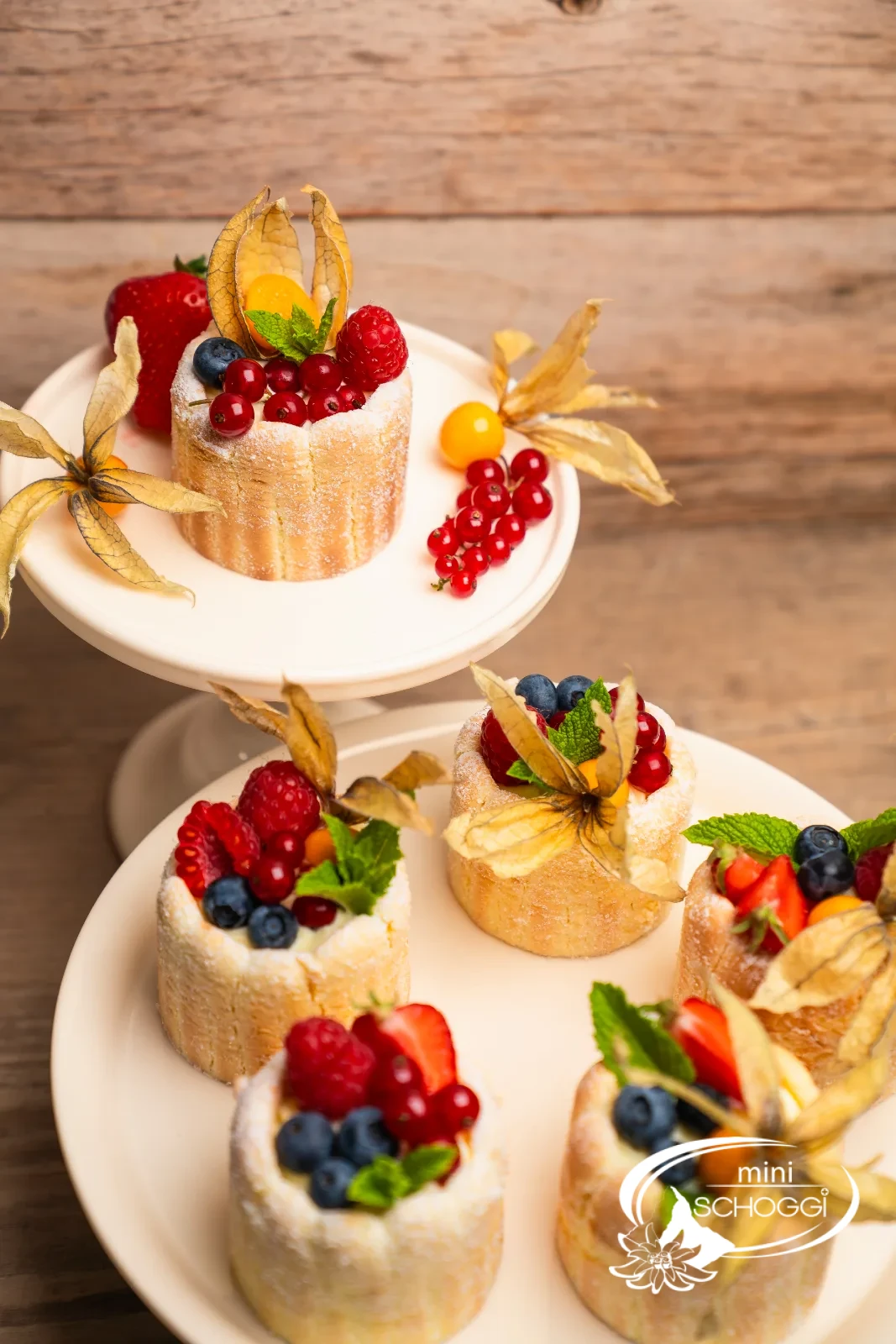 Beeren-Charlotte mit Physalis und Johannisbeeren auf Holztisch