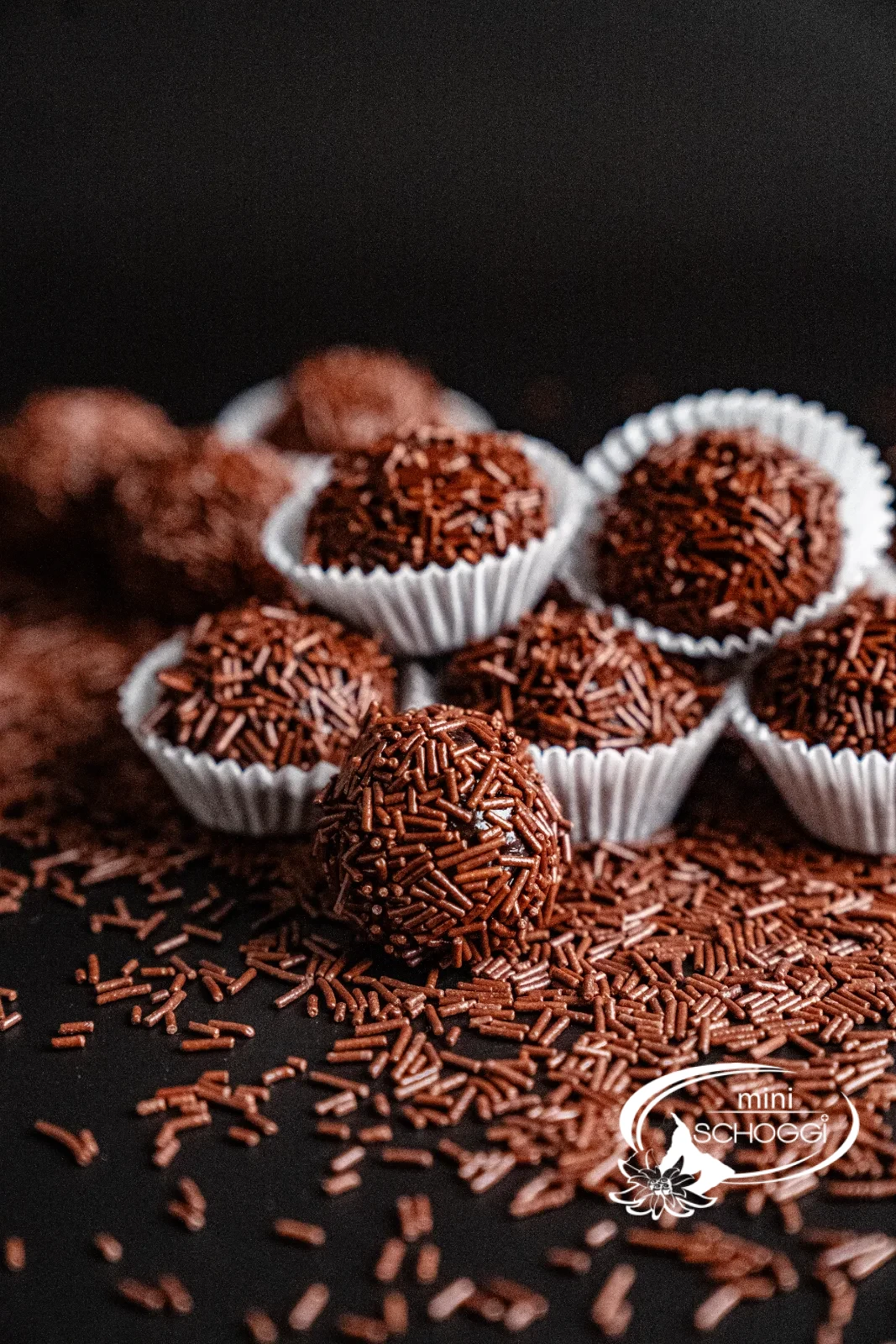 Brigadeiros roulés dans des vermicelles de chocolat, présentés dans des capsules de chocolat blanches