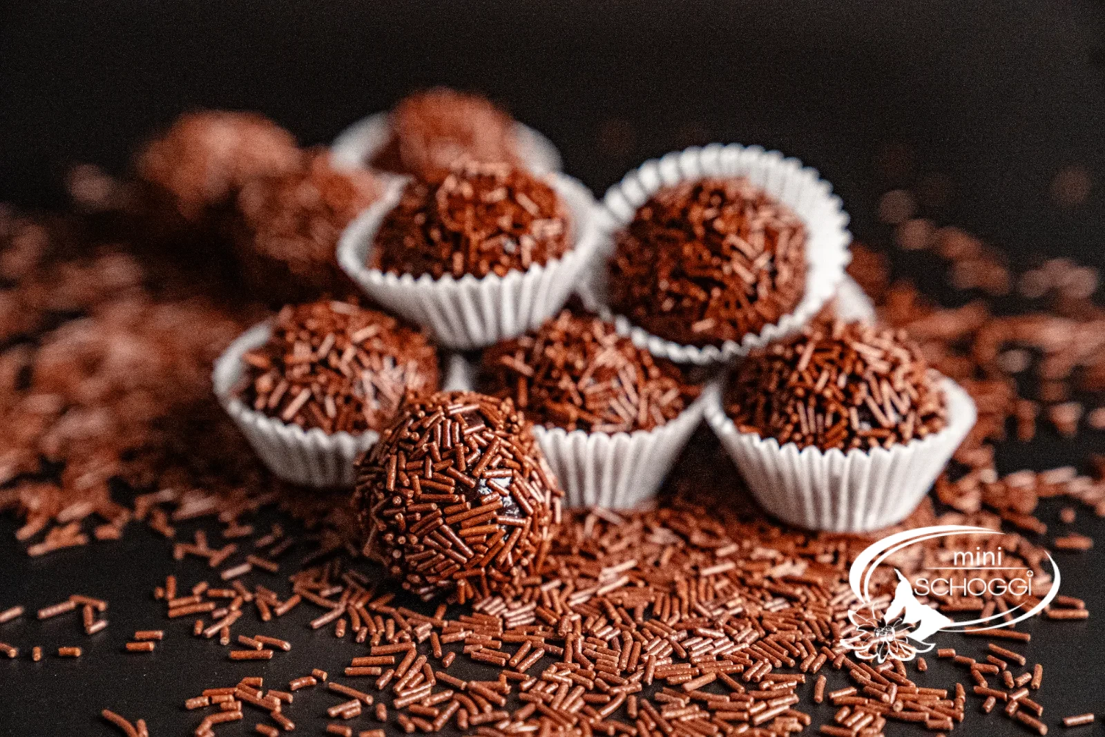 Brigadeiros roulés dans des vermicelles de chocolat, présentés dans des capsules de chocolat blanches