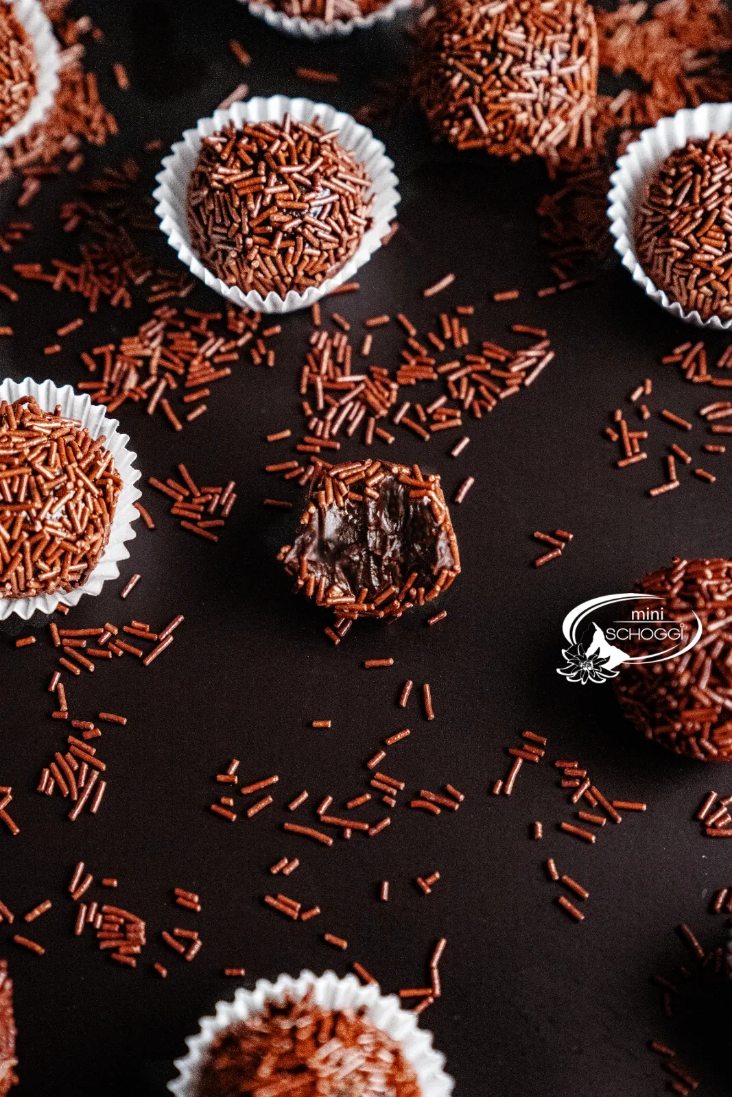 Brigadeiros roulés dans des vermicelles de chocolat, présentés dans des capsules de chocolat blanches