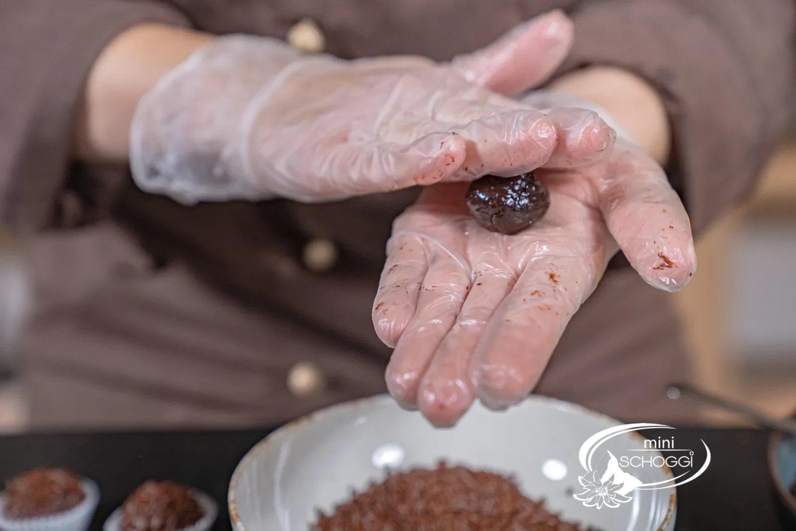 Une boule de brigadeiro est roulée entre les mains