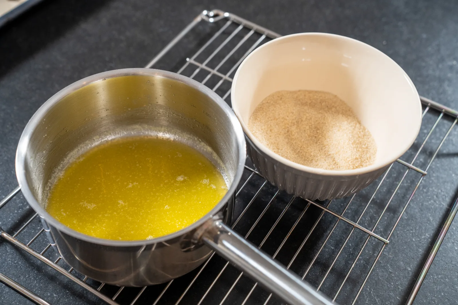 Browned butter in the pan next to a bowl of brown sugar