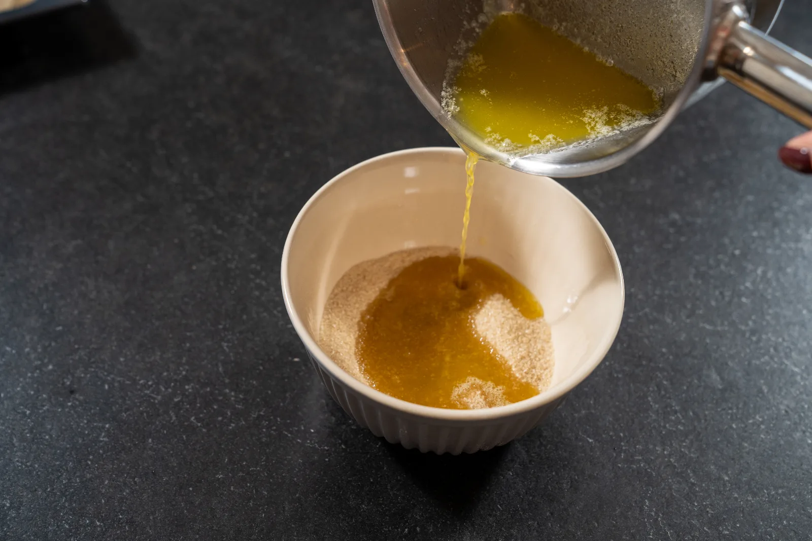 Browned butter being poured over the brown sugar in the bowl