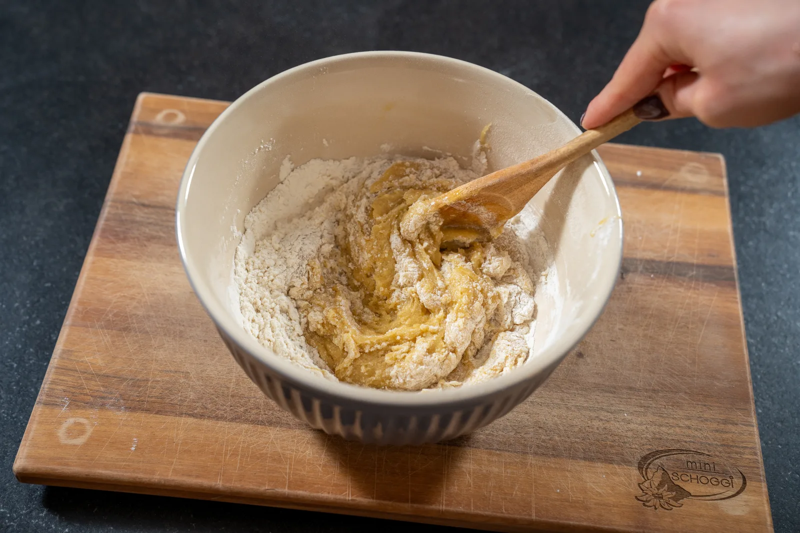 Flour being worked into the blondie dough with the wooden spoon