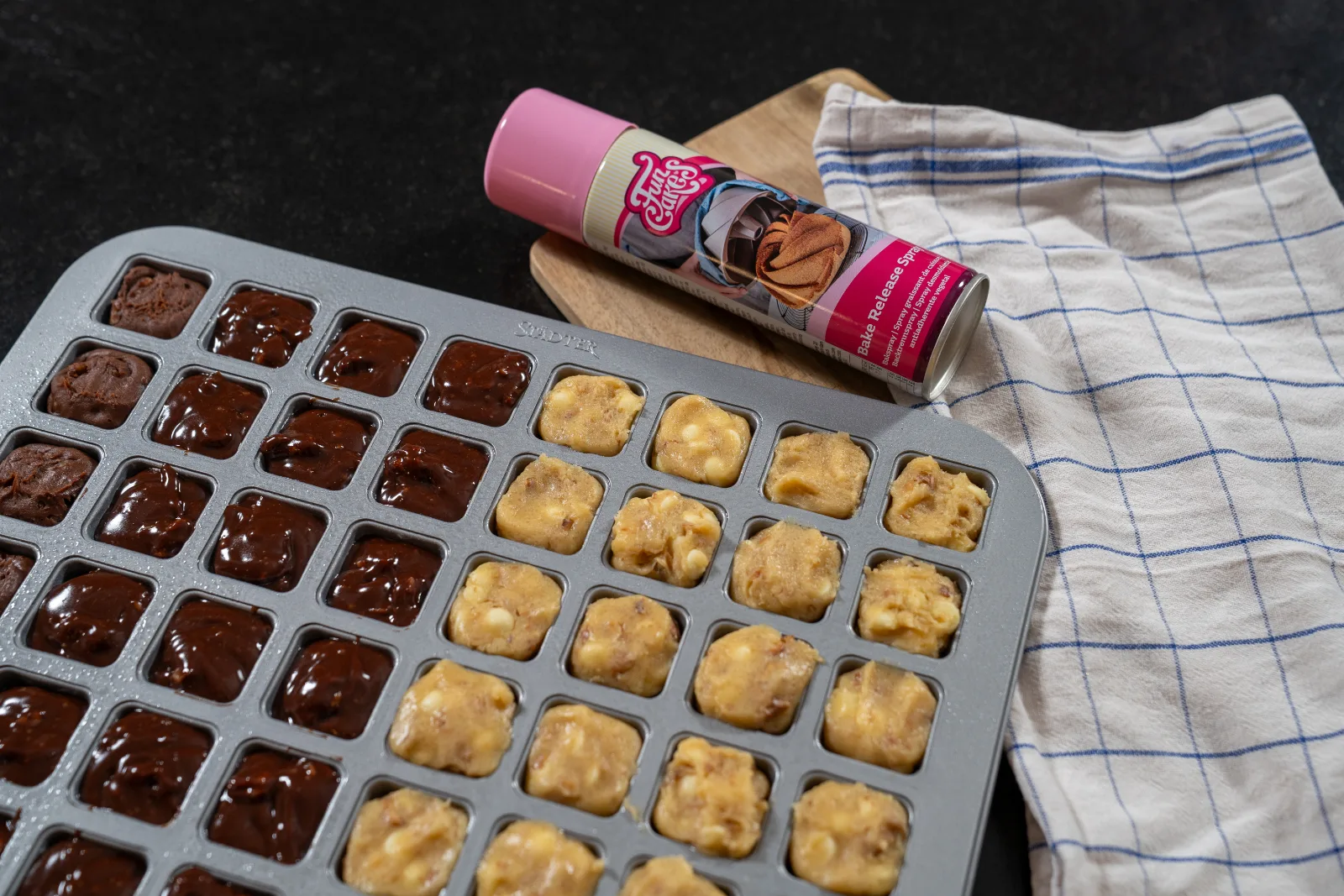 Baking tin filled half with brownie dough and half with blondie dough