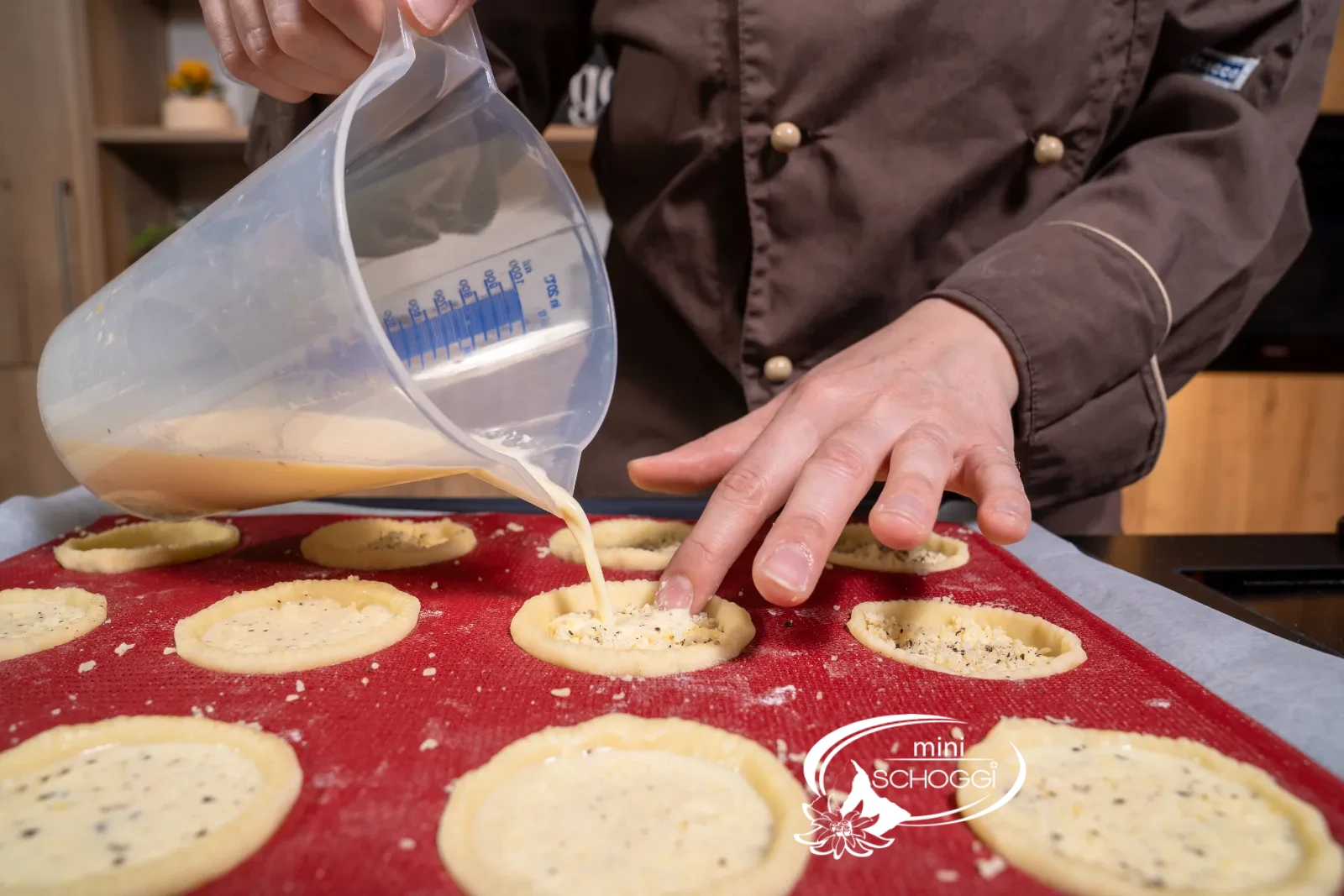 Il ripieno liquido viene versato con il misurino nei pasticcini preparati