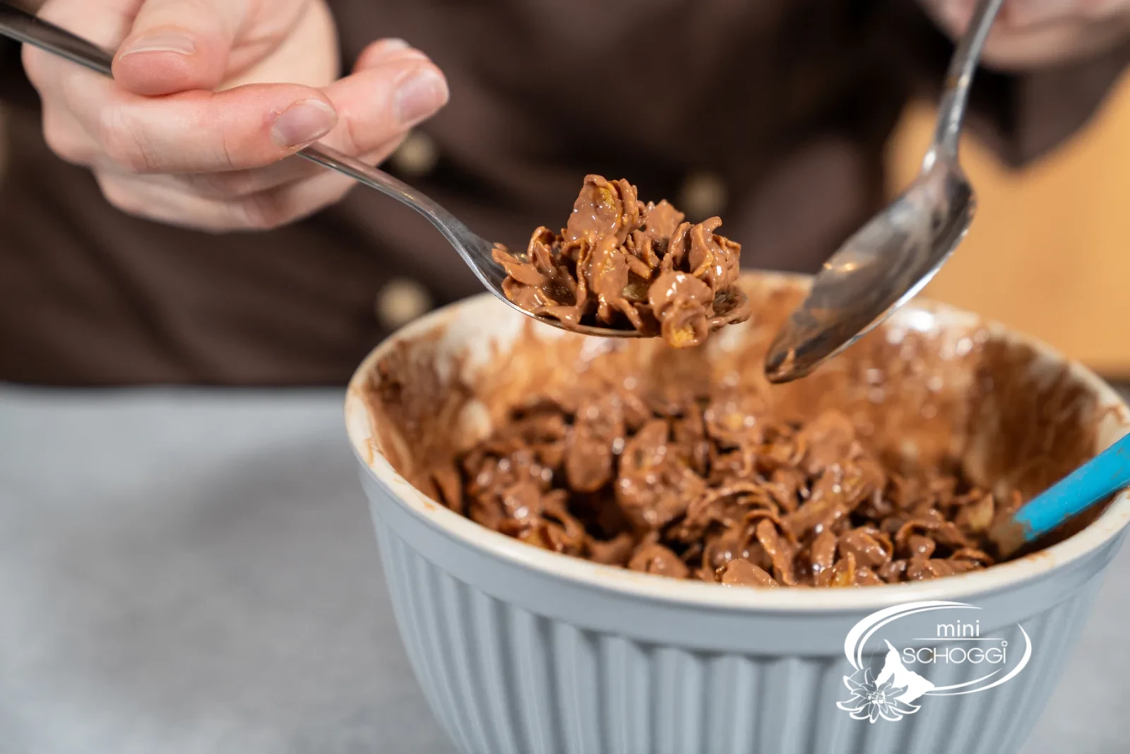 Un cucchiaino preleva il composto di cornflakes dalla ciotola