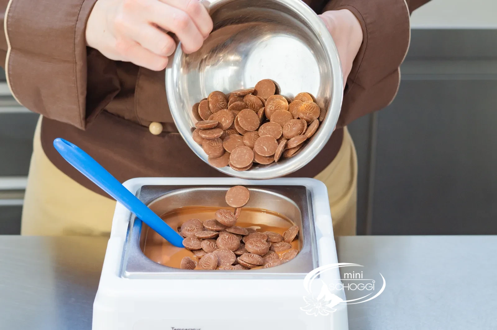 Couverturedrops werden in die geschmolzene Milchcouverture geimpft