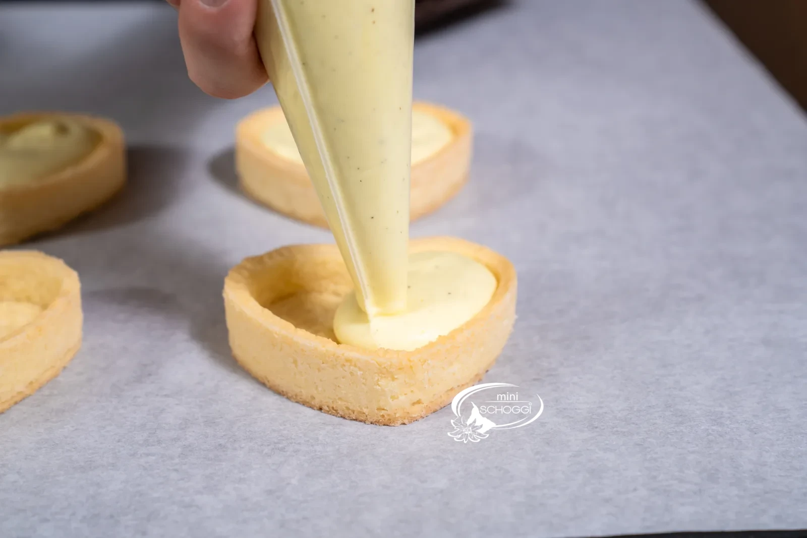 I fondi a cuore cotti vengono riempiti con la crema al limone e vaniglia