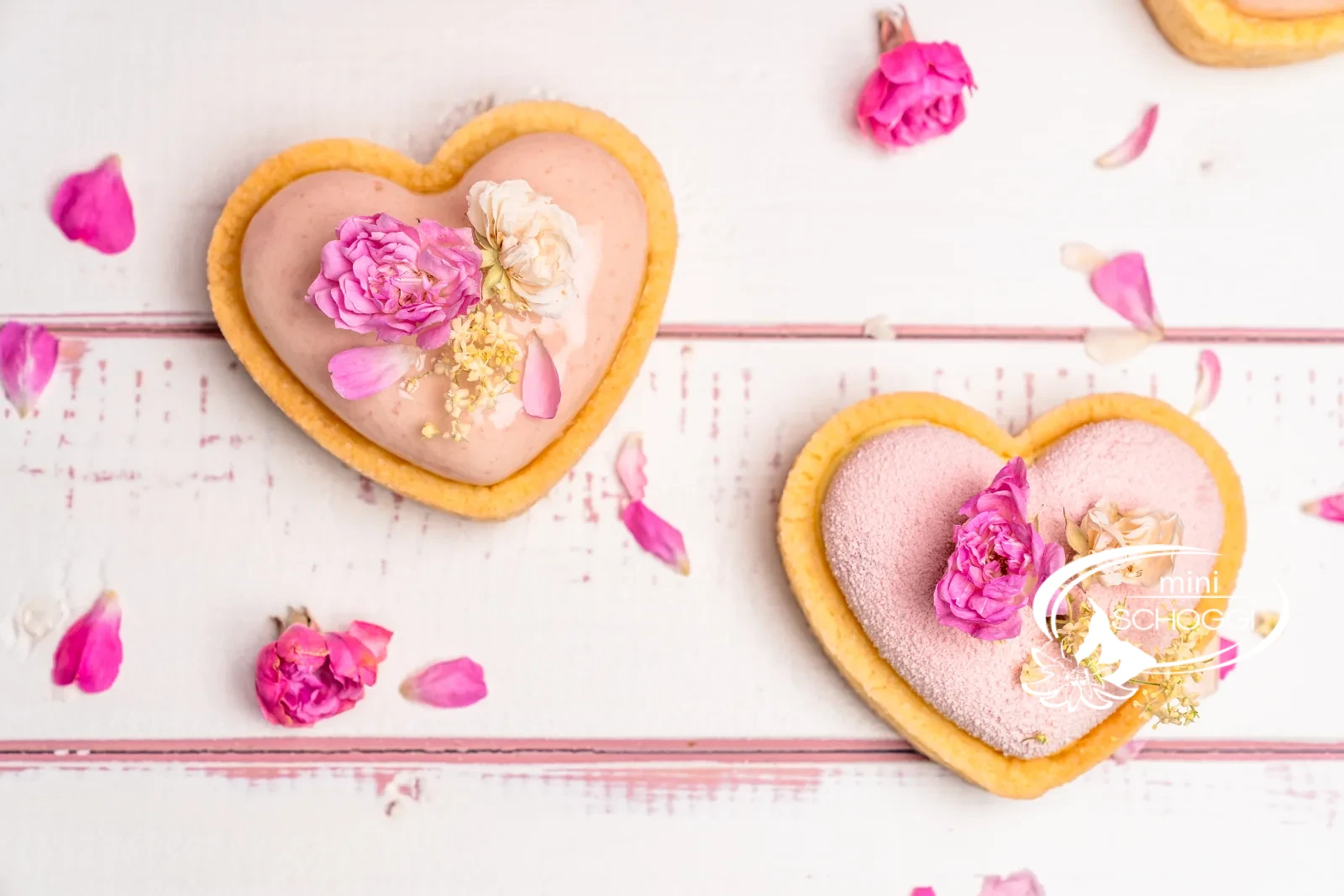 Pasticceria fragola-limone a forma di cuore con glassa rosa e boccioli di rosa commestibili
