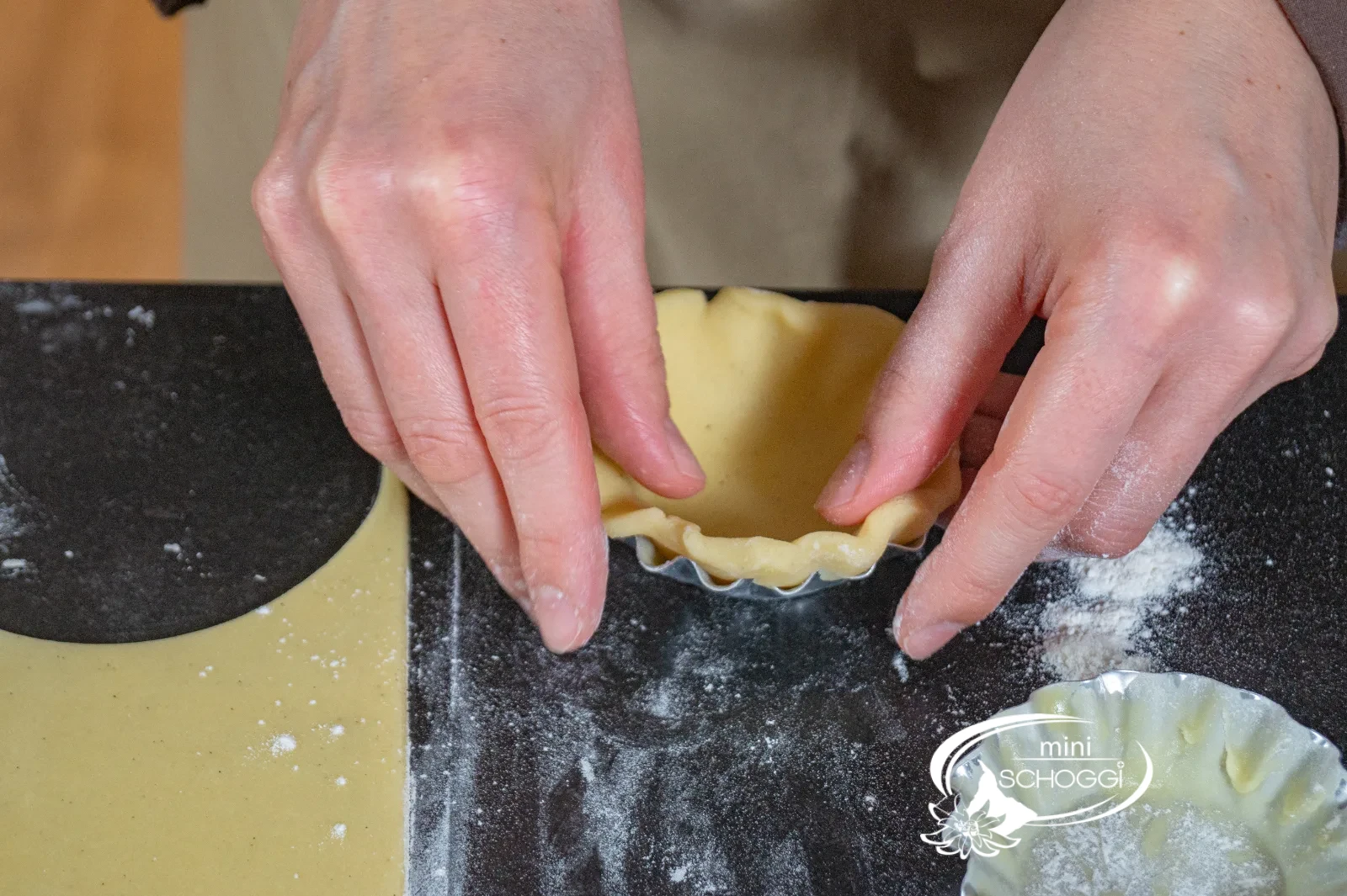 Il fondo di pasta frolla viene premuto nella teglia per crostata