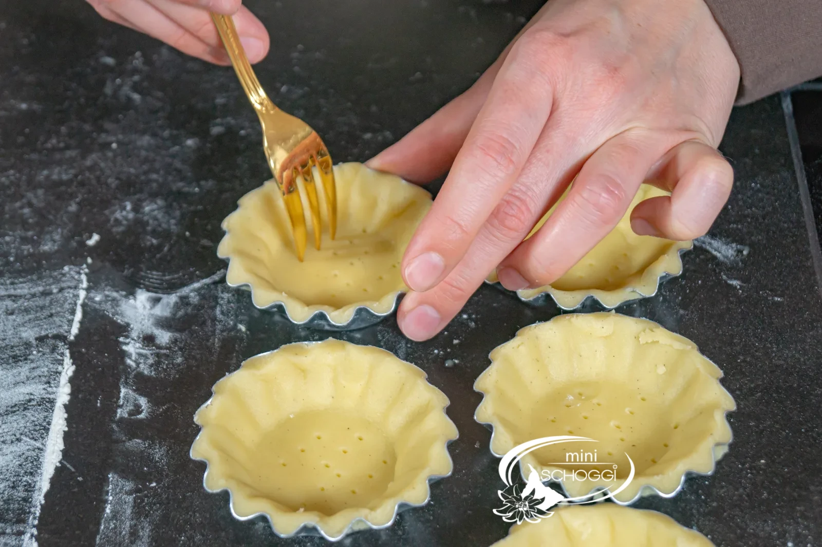 Il fondo di pasta frolla viene premuto nella teglia per crostata