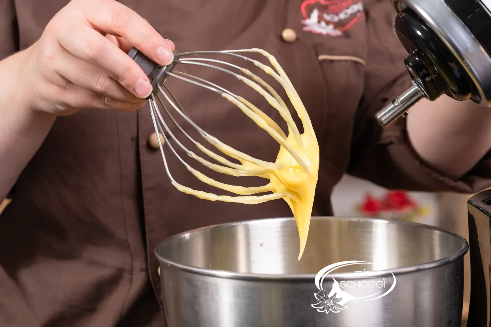 La crema alla vaniglia montata pende cremosa dalla frusta