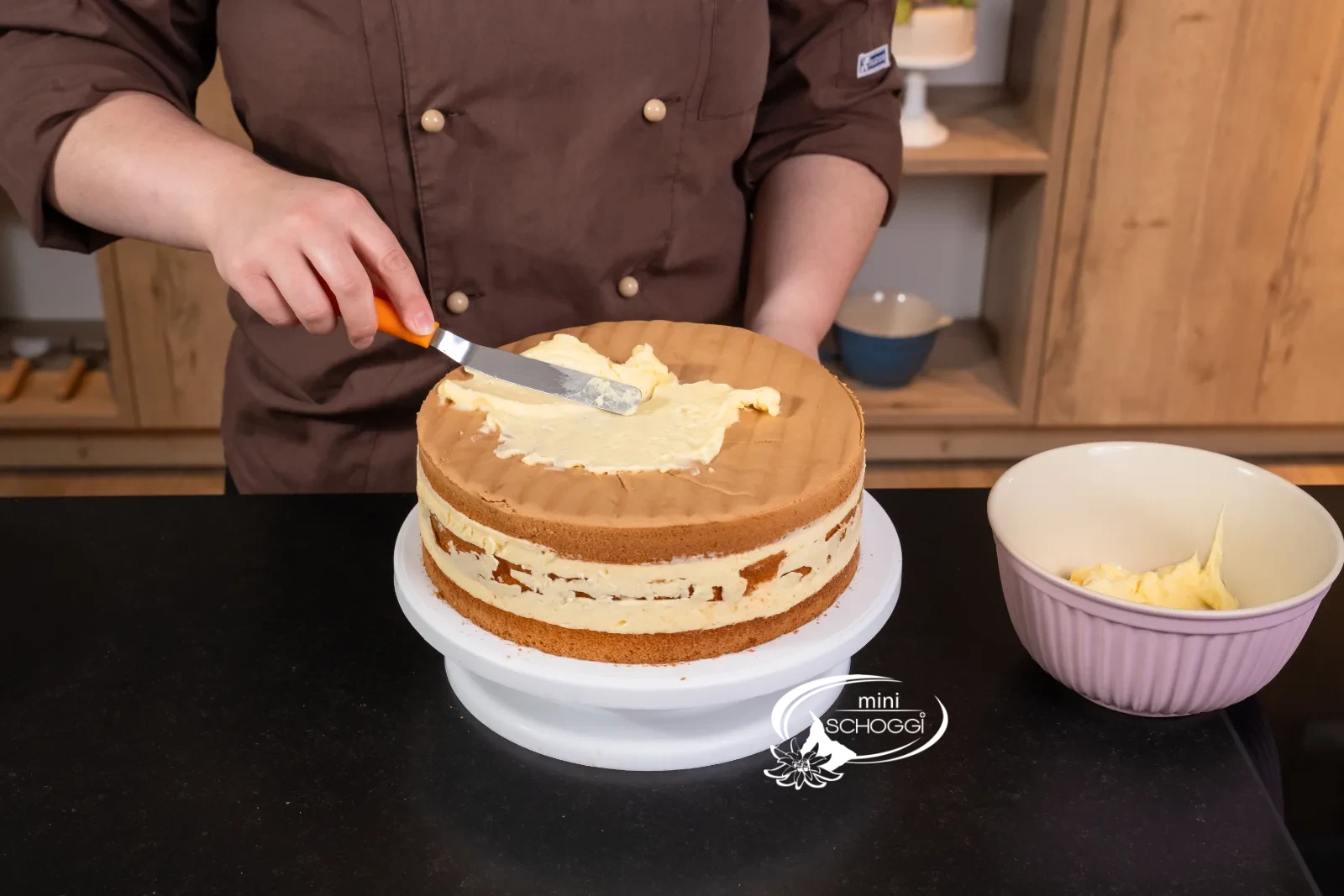 La torta viene ricoperta sopra con la crema alla vaniglia rimasta