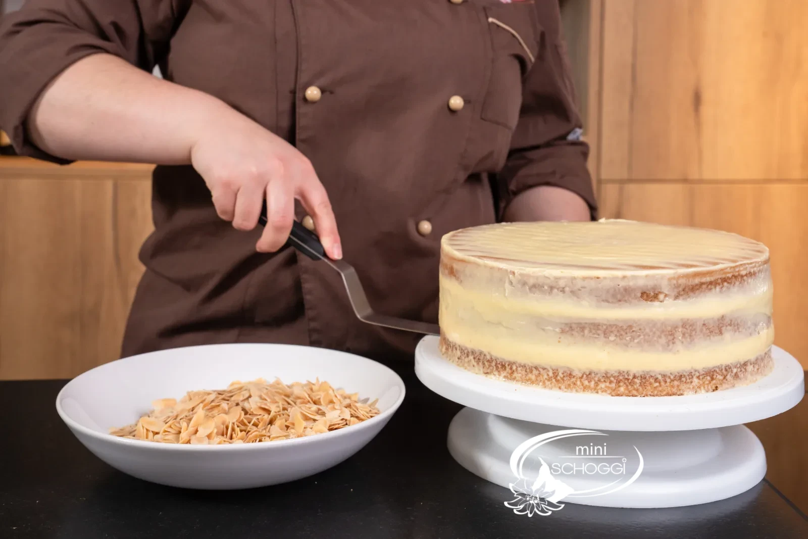 La torta viene sollevata con la spatola angolata e appoggiata sul palmo della mano