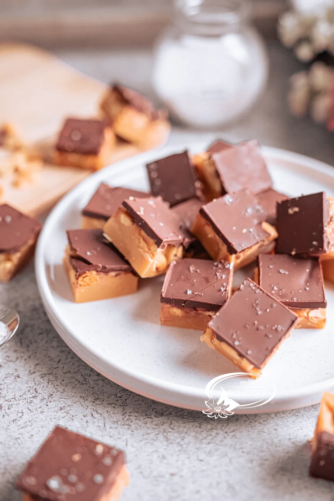 Cubetti di fudge alle arachidi con strato di cioccolato fondente su un piatto chiaro