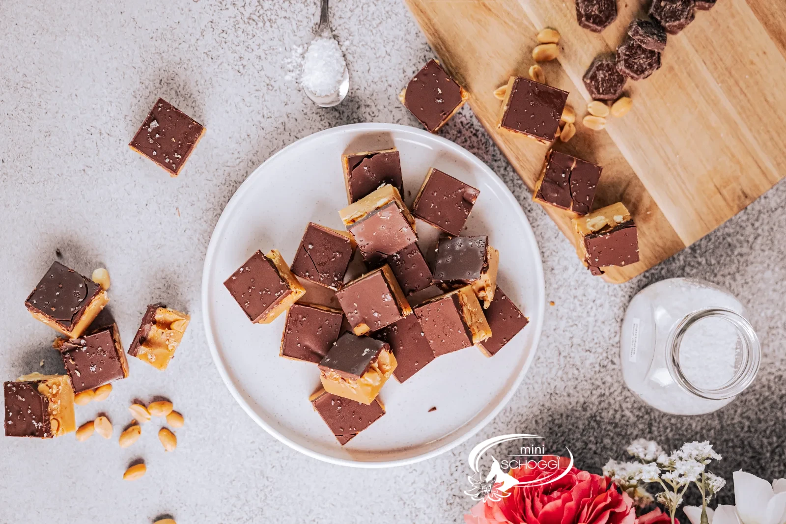 Cubetti di fudge alle arachidi con strato di cioccolato fondente su un piatto chiaro