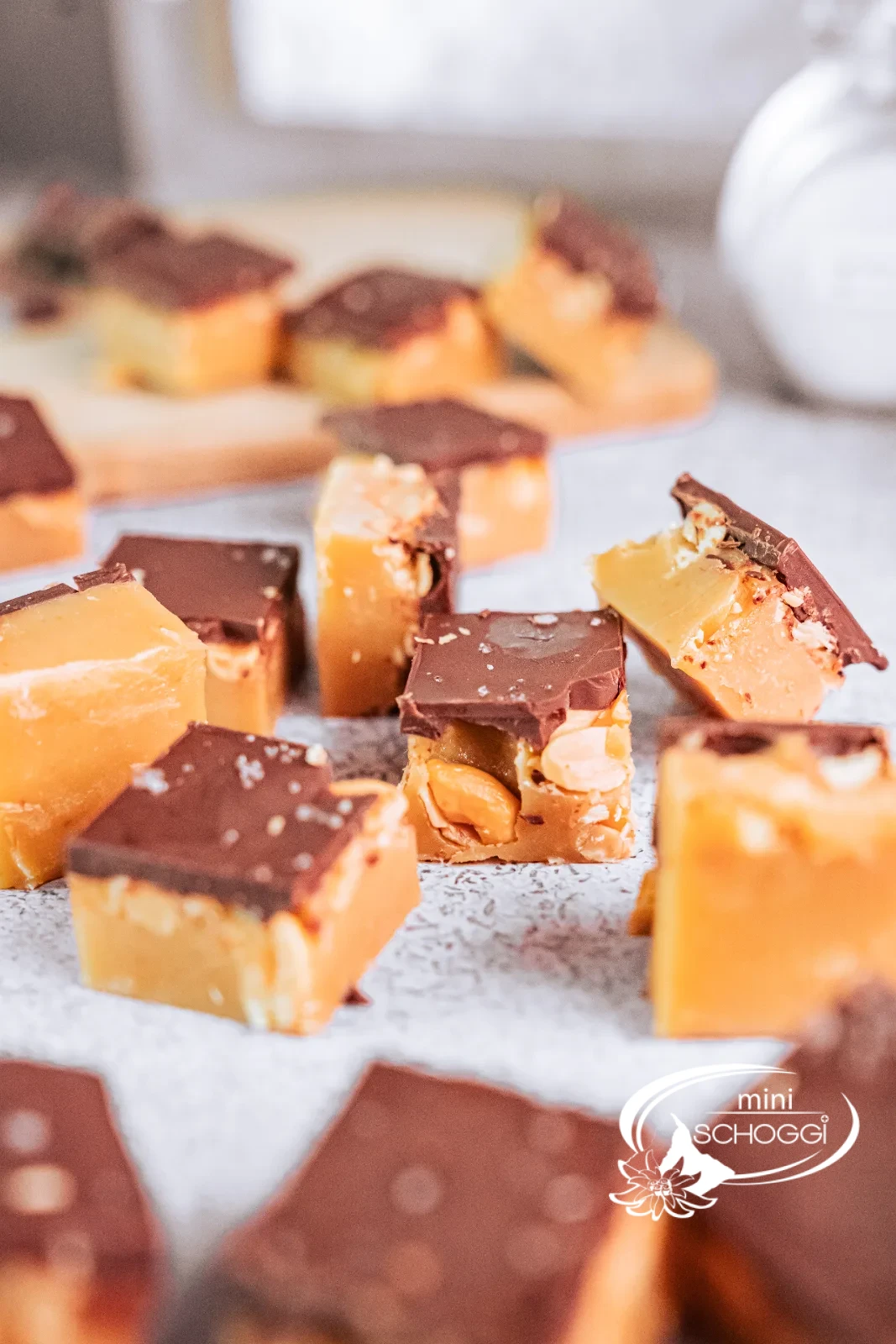 Cubetti di fudge alle arachidi con strato di cioccolato fondente su un piatto chiaro