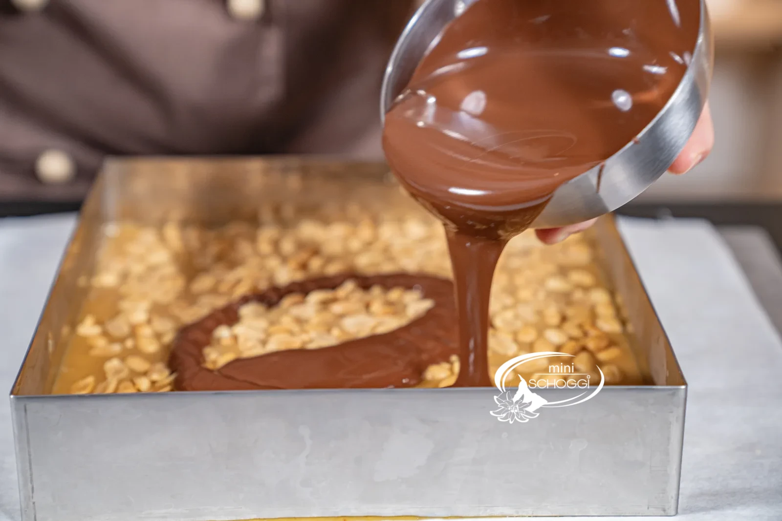 La copertura fondente temperata viene versata sul fudge raffreddato