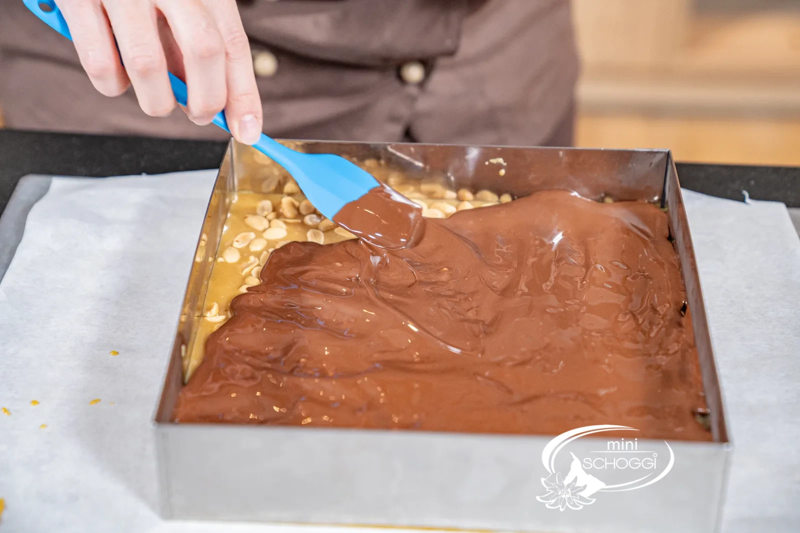 Lo strato di cioccolato viene steso in modo uniforme con la spatola in gomma