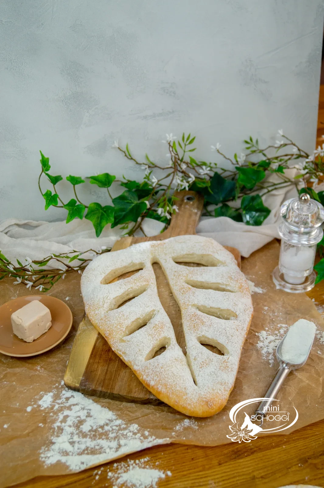 Mit Mehl bestäubte Fougasse neben einem Würfel Hefe
