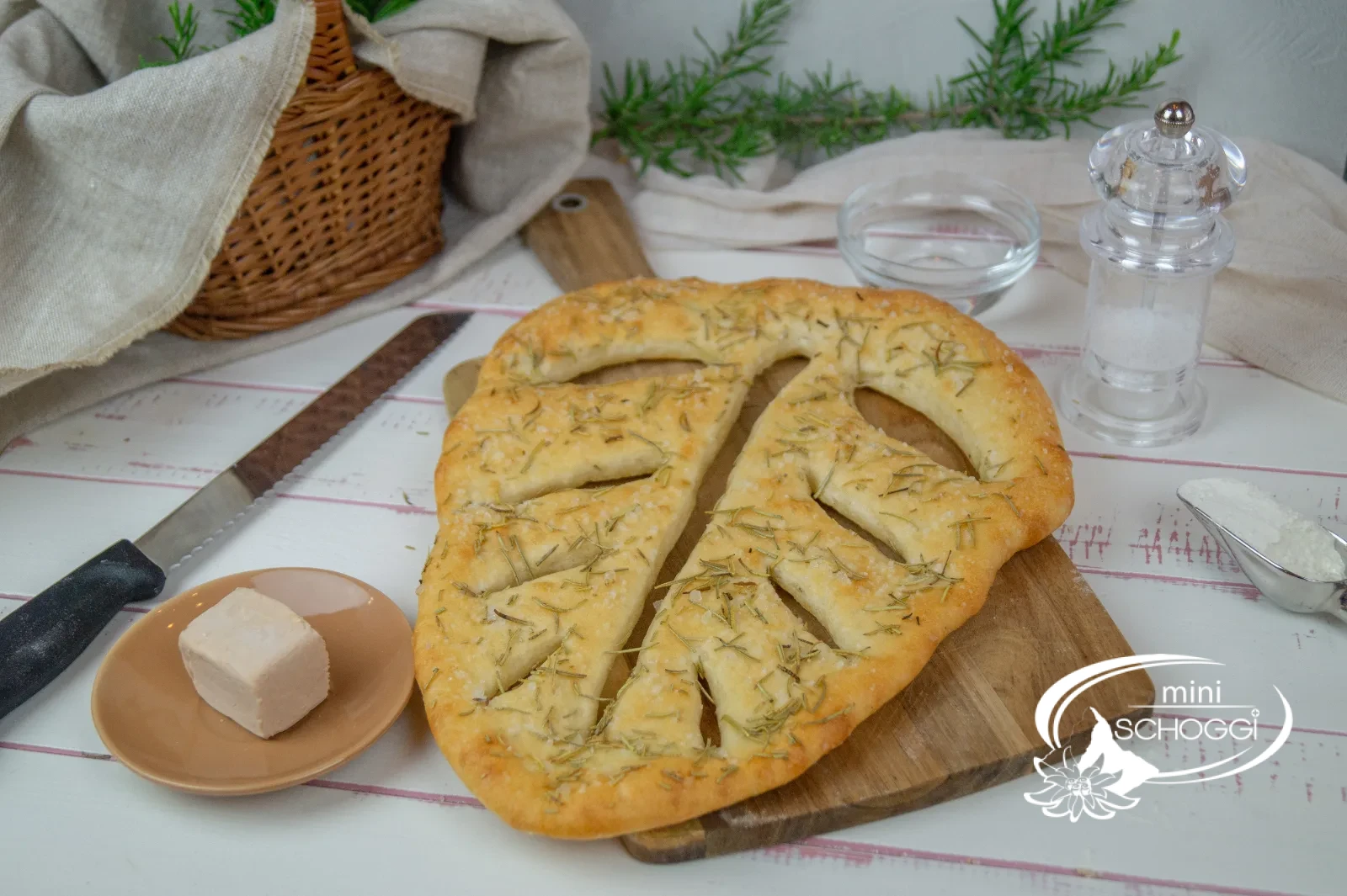 Fougasse appena sfornata con erbe aromatiche su un tagliere di legno