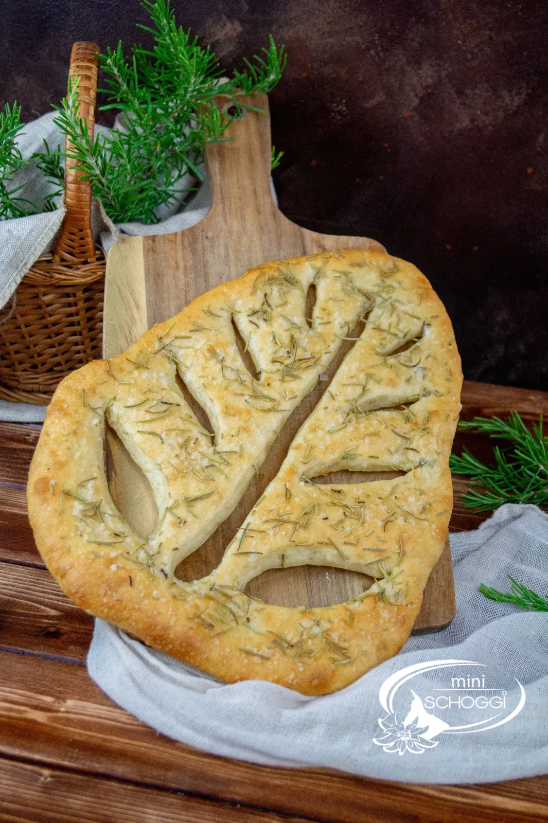 Fougasse appena sfornata con erbe aromatiche su un tagliere di legno