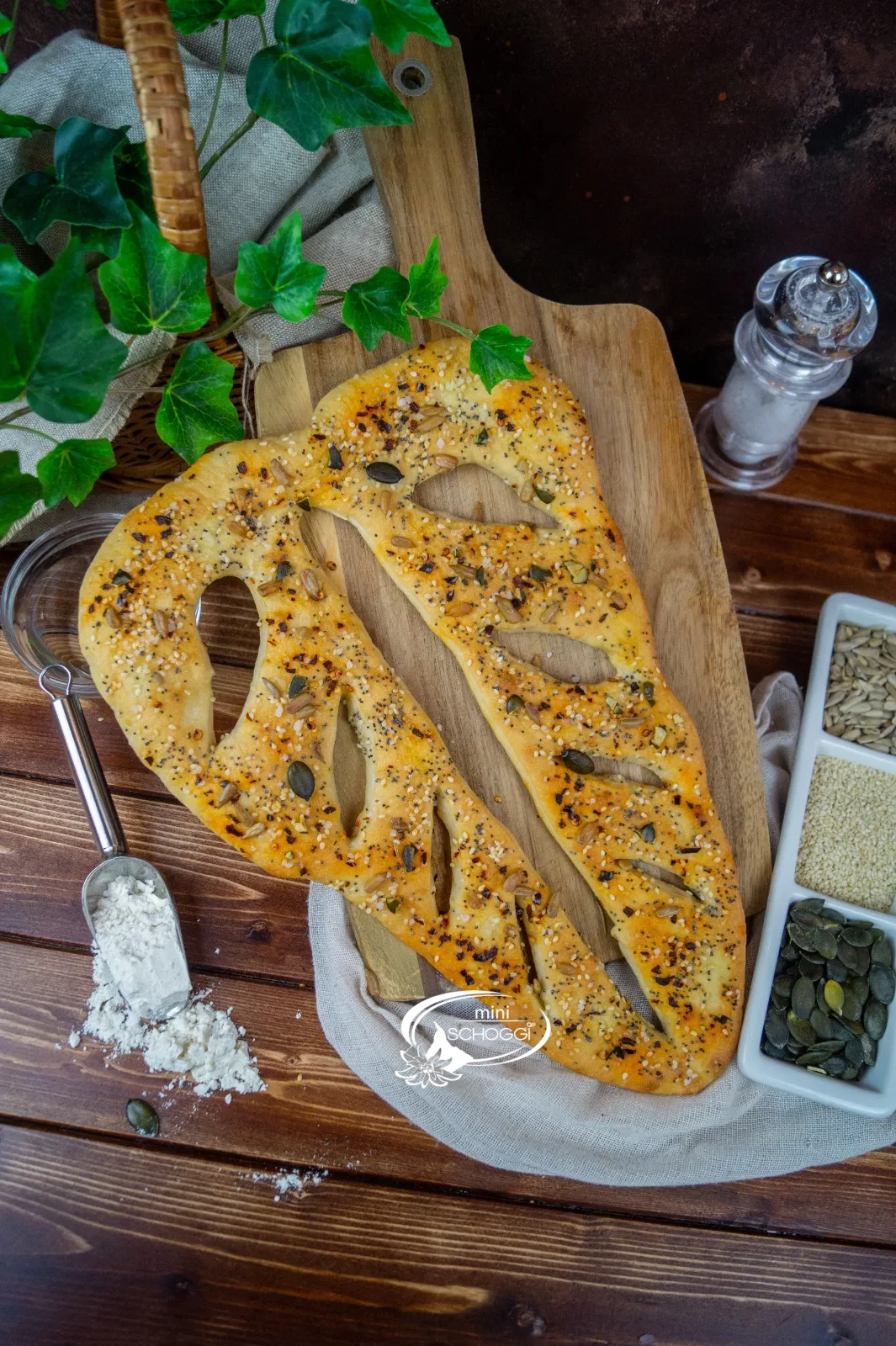 Fougasse appena sfornata con erbe aromatiche su un tagliere di legno