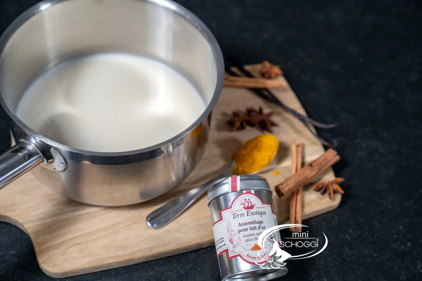 Kalte Milch im Topf, daneben die Gewürzmischung, Zimtstangen und Kurkuma