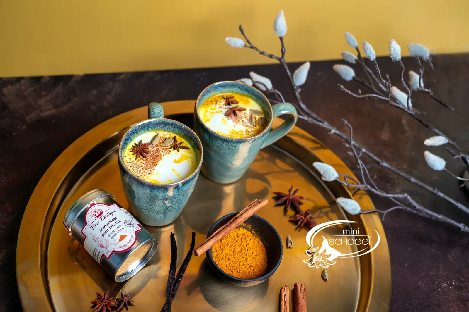 Zwei Tassen Golden Milk mit Gewürzmischung und gemahlenem Kurkuma auf dem Tablett