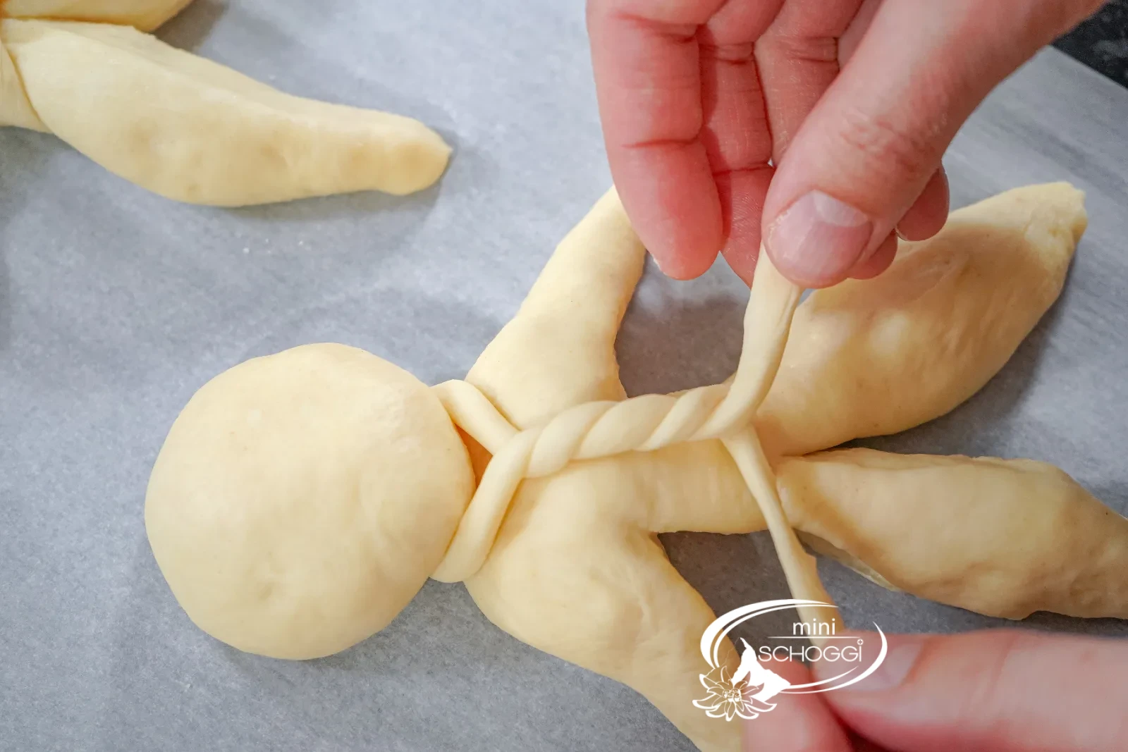 La sciarpa attorcigliata viene posata attorno al collo dell'omino di pasta lievitata