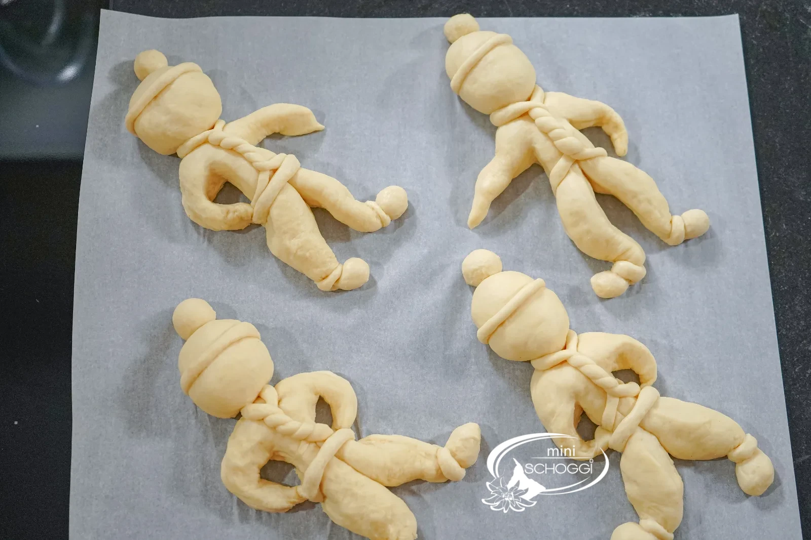 La sciarpa attorcigliata viene posata attorno al collo dell'omino di pasta lievitata