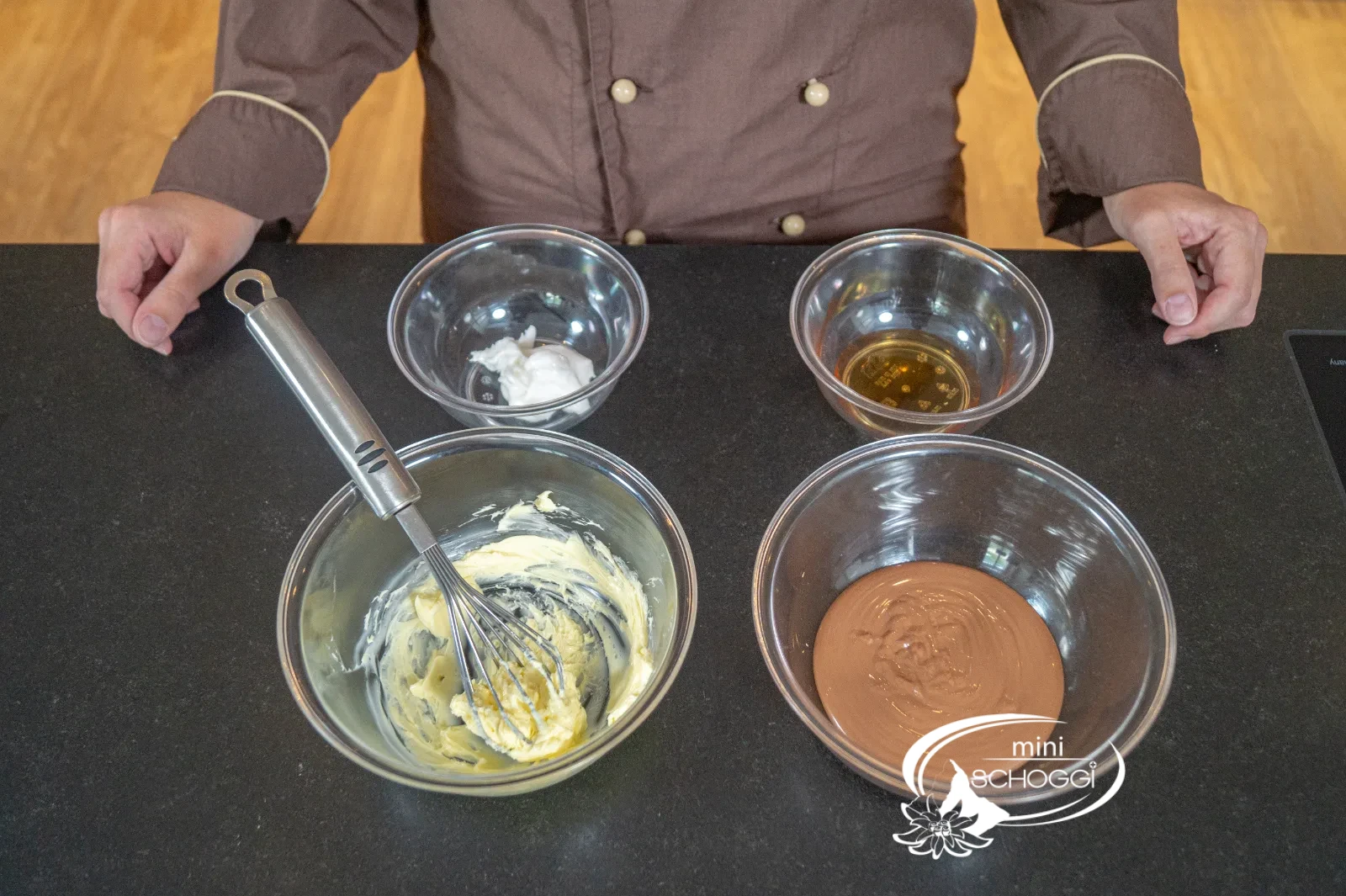 Abgewogene Zutaten für die Butterganache in Glasschüsseln: Butter, Schmelzfondant, Sirup und temperierte Couverture
