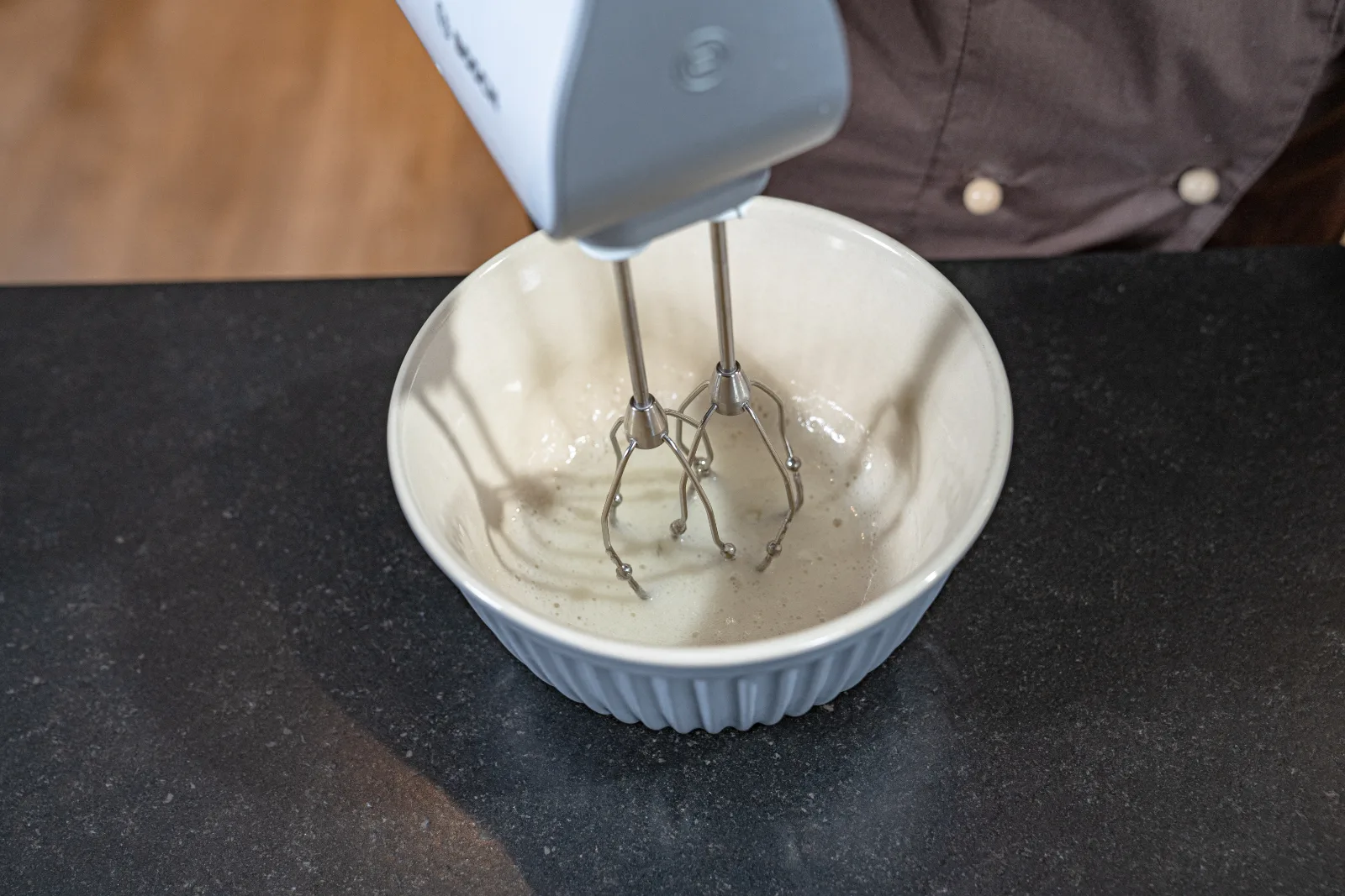 The egg white is whipped until foamy in the bowl