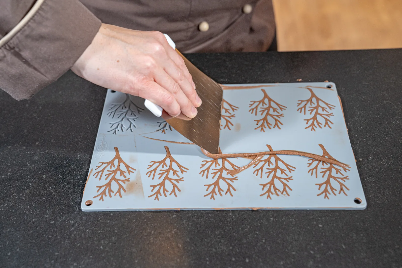 The excess mixture is pulled off the branch motif with the metal horn