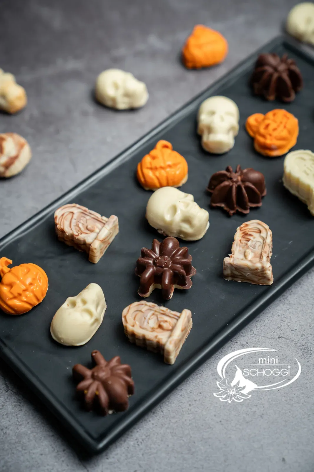 Halloween-Schoggiguetzli mit Zange auf einer Platte
